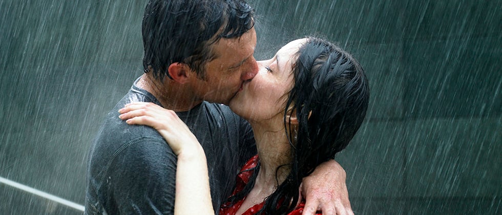 A couple kiss passionately in the pouring rain