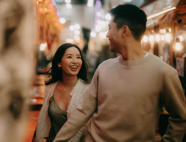 A man and a woman smiling at each other while walking