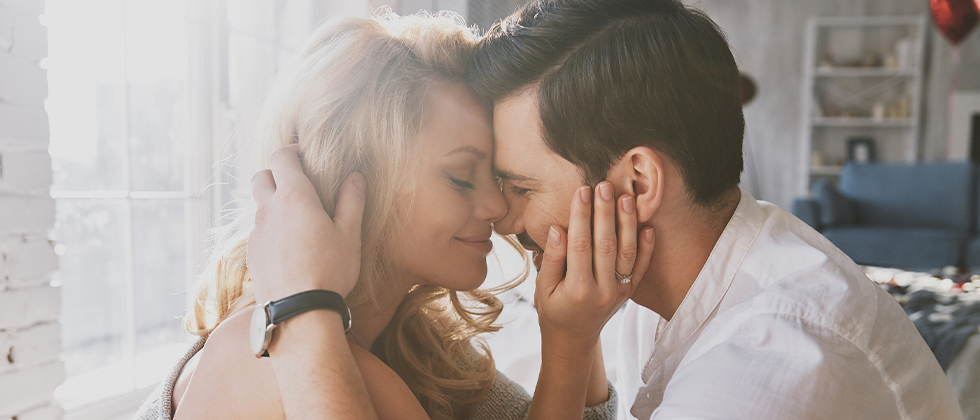 An affectionate couple embrace in their living room