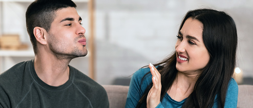 A woman rejects a man's attempt to kiss her