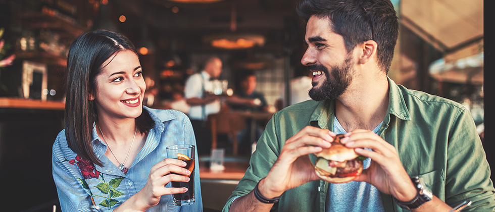 A couple smile at each other in a fashionable restaurant