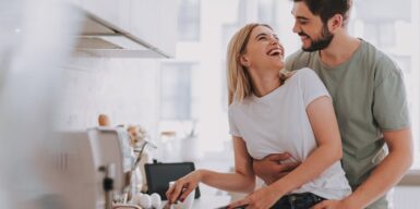 Couple in the kitchen cooking and laughing together