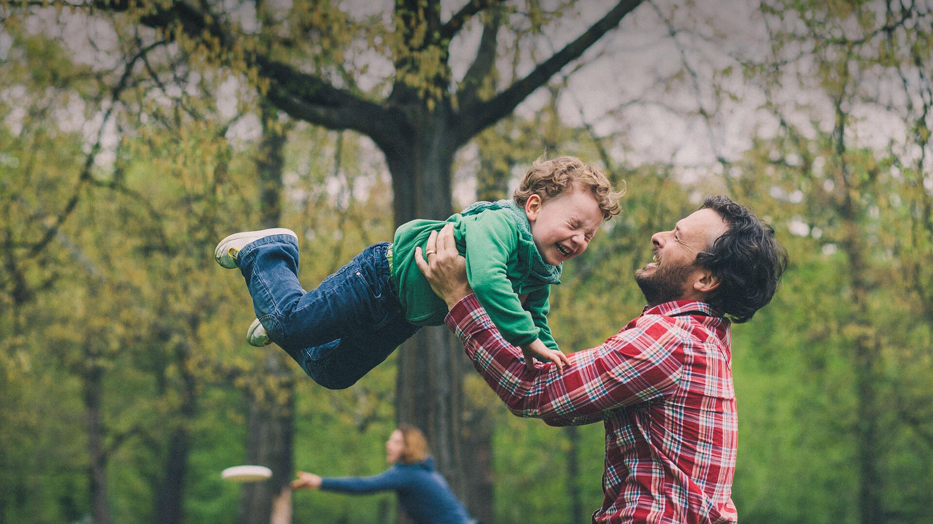 Single parent dating symbolized by a single dad who is tossing his little son in the air on a playground in Australia