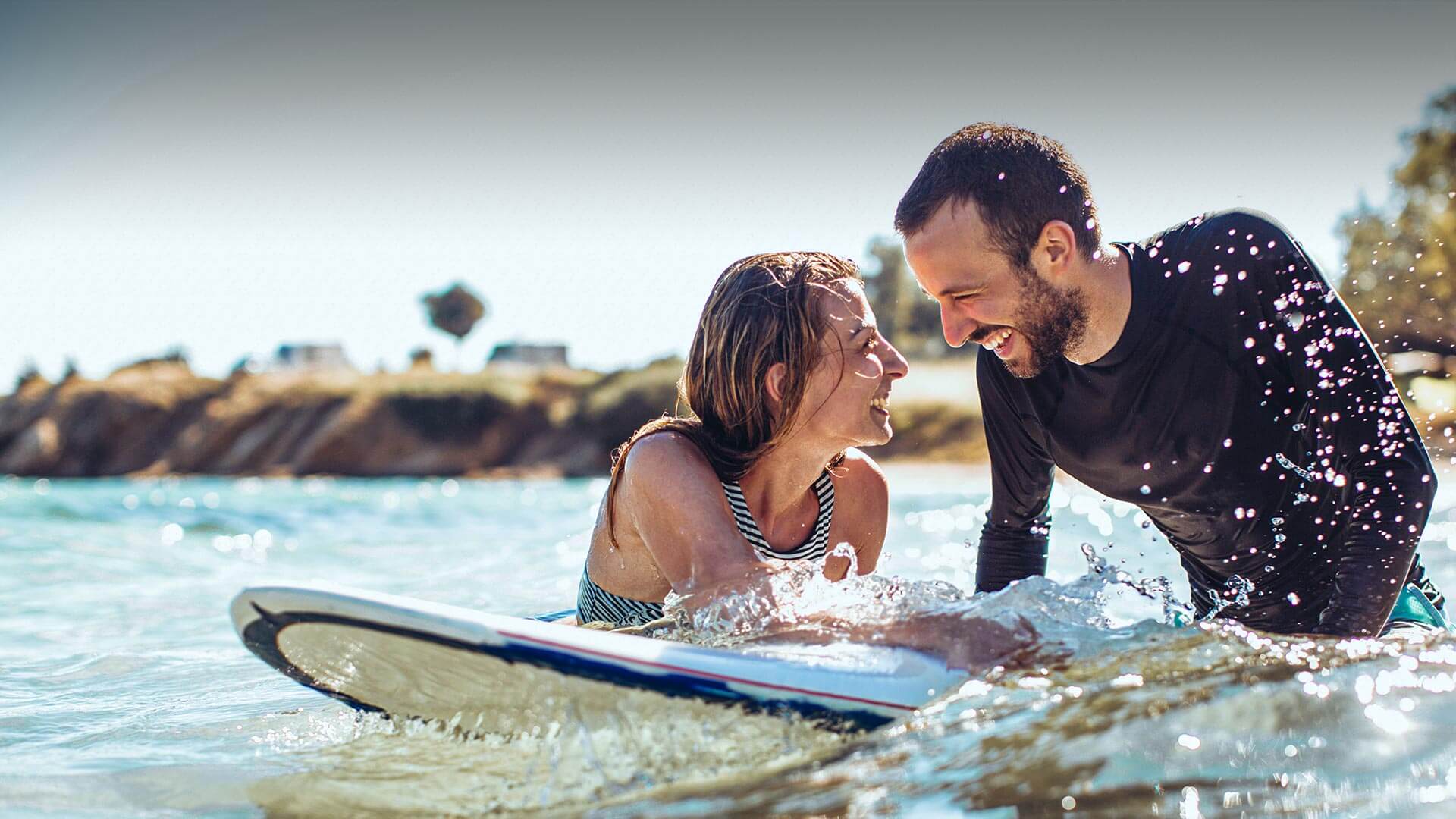 Greek Dating in Australia symbolized by a couple that smiles each other in the sea