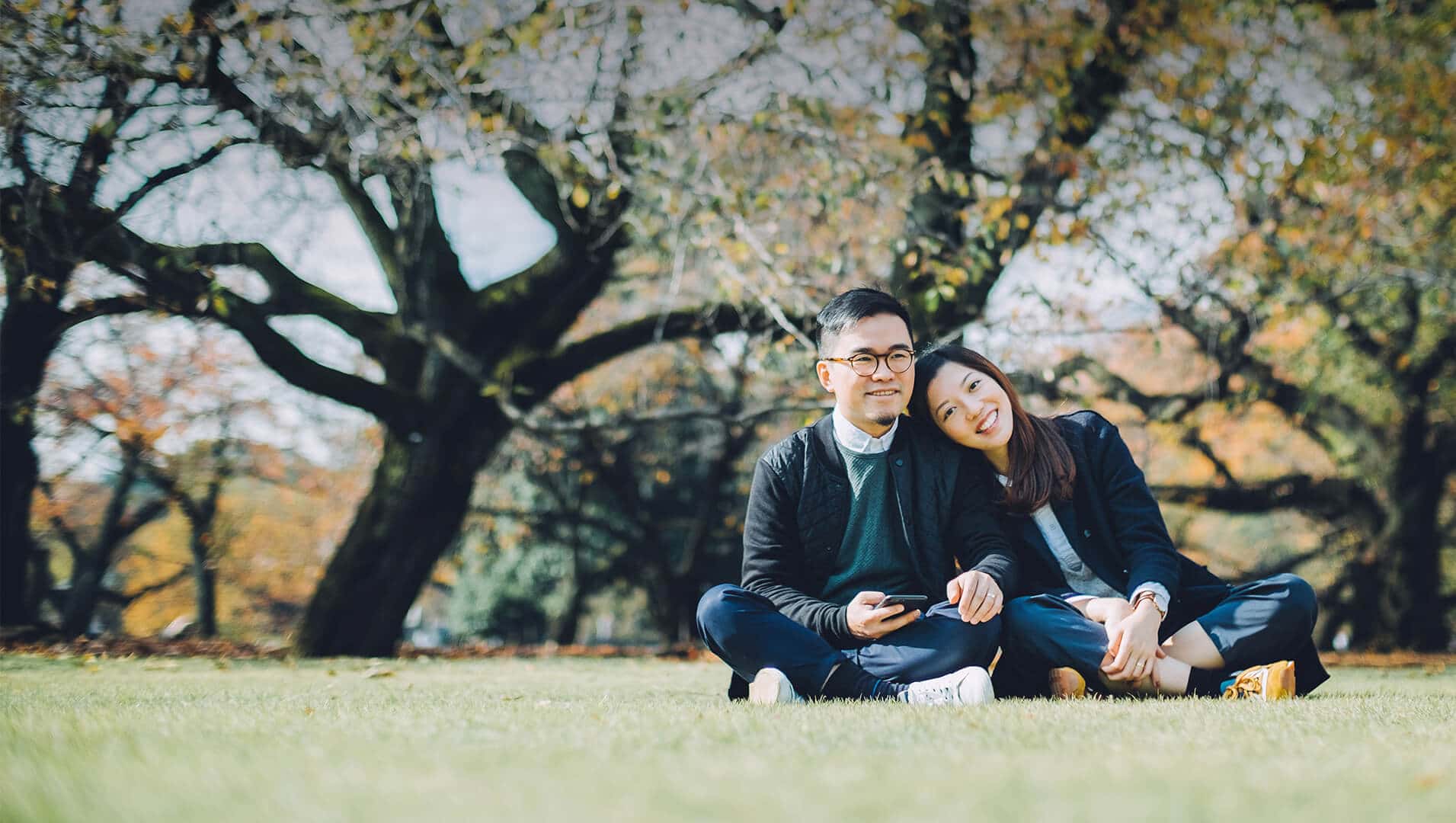 Japanese dating symbolized by a man and woman sitting cross-legged next to each other on a green field in Australia