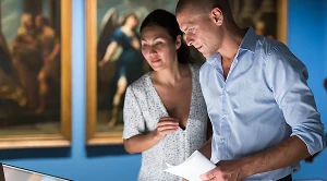 A couple browsing a museum together on a date and looking at various pieces.