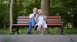 A couple sitting on a park bench together.