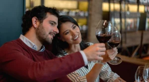 A couple holding glasses of wine in their hands.