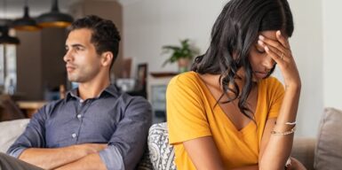 Young couple sitting together looking detached from one another