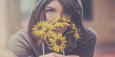 Sad woman holding a bouquet of wilting flowers