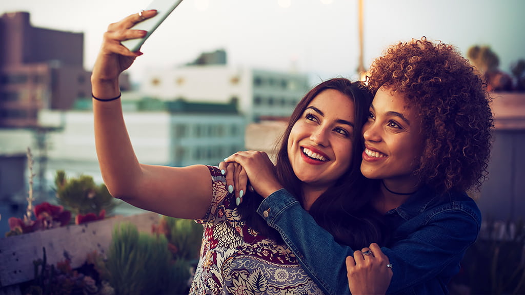 Lesbian dating illustrated by two women who embrace each other and take a selfie