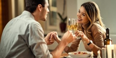 Man and woman sitting on bench looking at each other as symbol for first date tips
