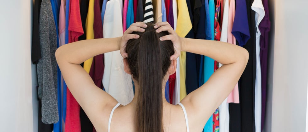 Woman standing in front of her closet not knowing what to wear