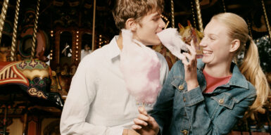 Man and woman eating cotton candy together and laughing as example how to flirt