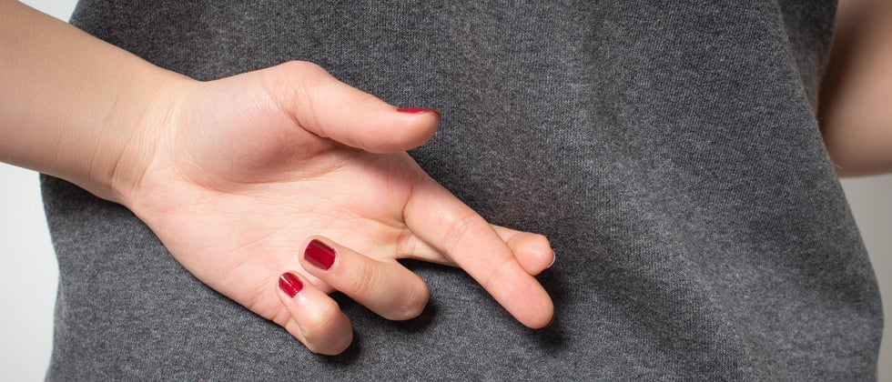 A woman crossing her fingers behind her back