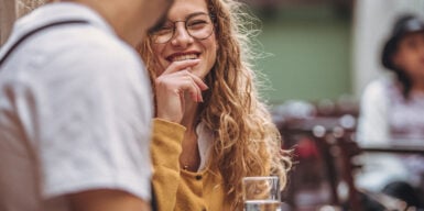 Woman smiles at man as example of good conversation starter with women