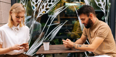 Man and woman both sitting on cell phone as symbol for dating red flags