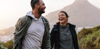 Young couple hiking in the mountains and laughing the whole way