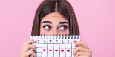 Woman holding a calendar with a date marked for every day that week