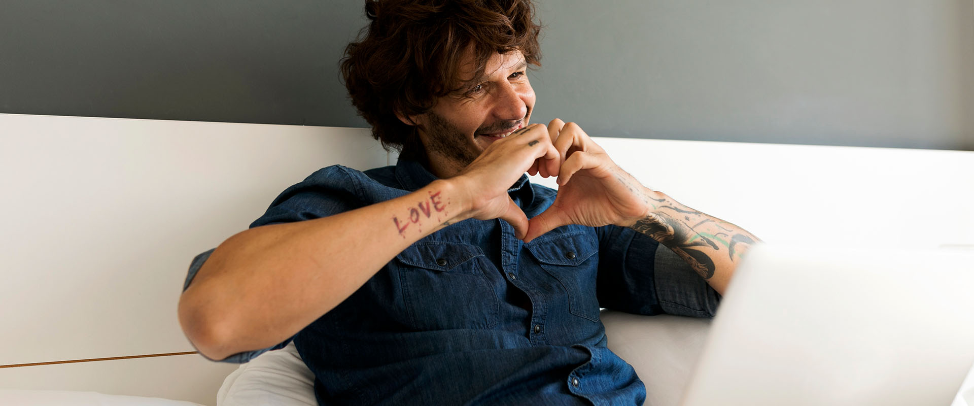 Man holding a heart with two hands in front of his chest as a symbol for long-distance relationships