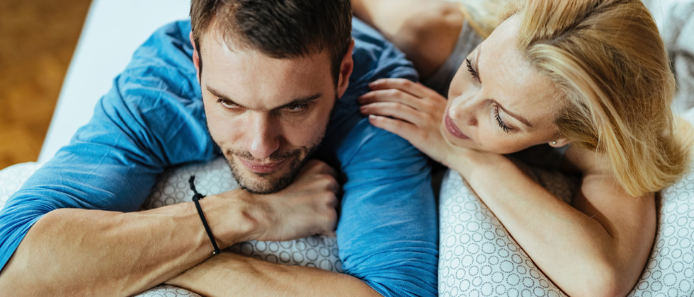 Man and woman on sofa and he looks thoughtful as symbol of love but not in love