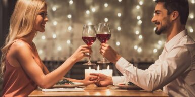 A couple on a date drinking wine and holding hands