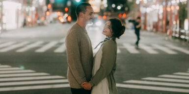 Man and woman standing holding hands on the street on their third date