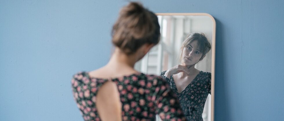 Woman looks thoughtfully in the mirror and is unlucky in love