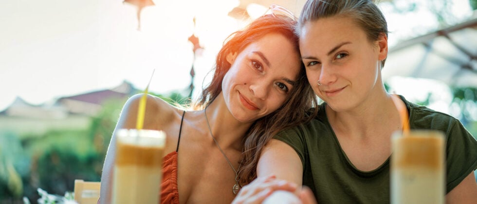 Two woman smiling in camera as symbol for lesbian relationship