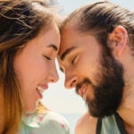 A woman and a man touching their foreheads, initiating physical touch as love language