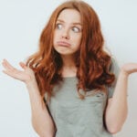 Girl looks amazed and raises hands in the air as a symbol of questions that you can ask a girl