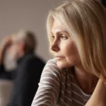 A couple who just broke up. She's slowing turning around to her ex partner in the background.