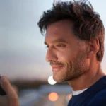 Man on his phone in front of a sunset