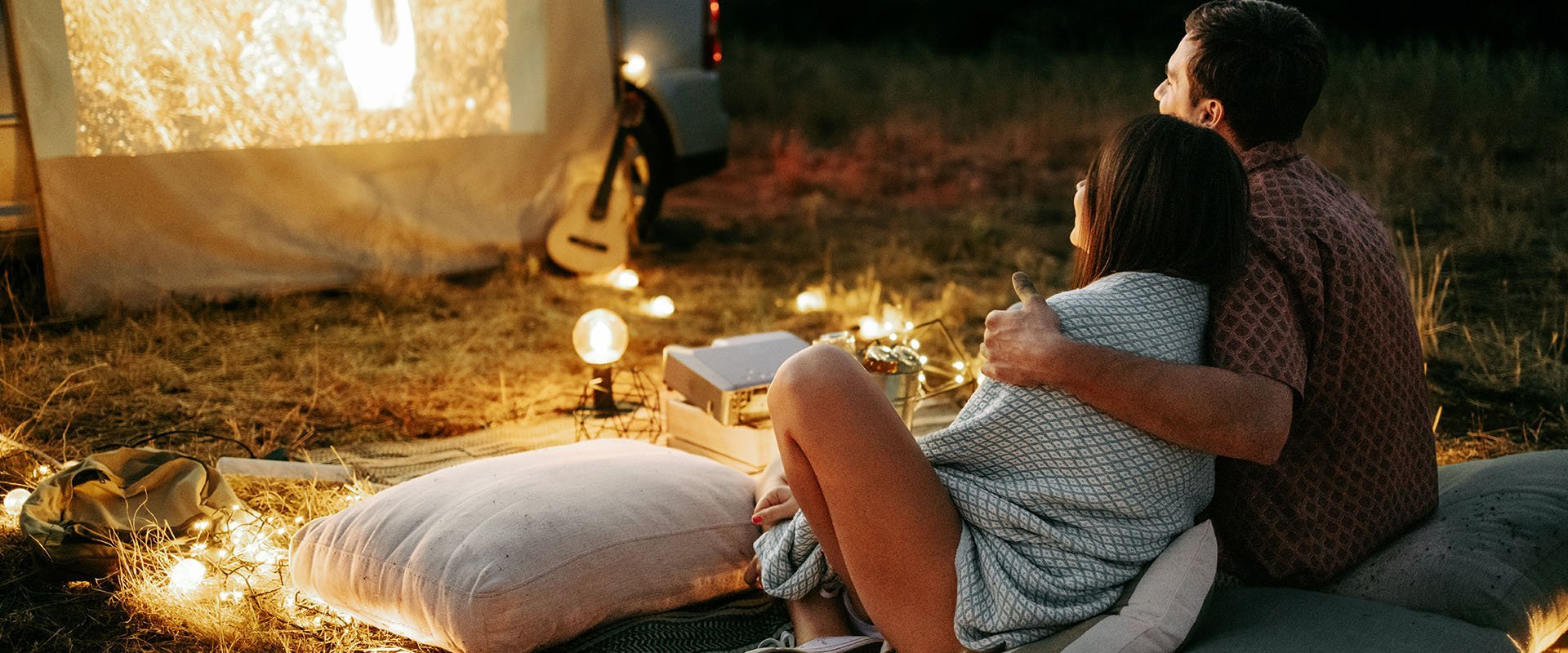 Man and woman have an outdoor date and watch a movie as an example of date ideas
